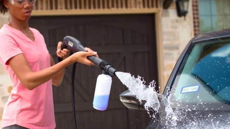 mulher lavando seu carro com lavadora de alta pressão com aplicador de detergente