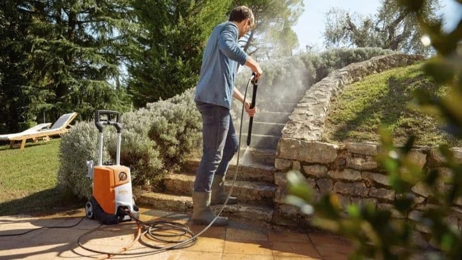 homem lavando escadaria de pedra de residência com lavadora de alta pressão Stihl